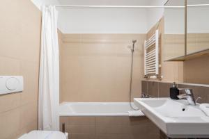a bathroom with a sink and a tub and a toilet at White Cascade Realty Apartment in Budapest +17 photos
