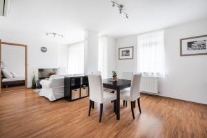 uma sala de estar com uma mesa de jantar e cadeiras brancas em White Cascade Realty Apartment em Budapeste