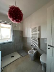 uma casa de banho com um WC e uma bola vermelha em Claretta’s Home em Iglesias