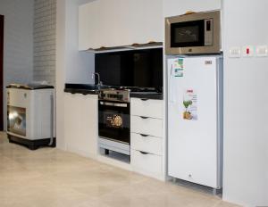 una cucina con forno a microonde e frigorifero di سمت للشقق المخدومة السلام a Riyad