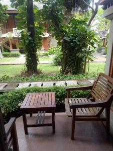 zwei Bänke und ein Tisch auf einer Terrasse in der Unterkunft Kun's Stay Private Apartments in Seminyak