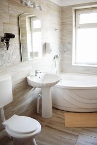 a bathroom with a tub and a sink and a toilet at Hotel Solar in Focşani