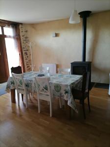 une salle à manger avec une table, des chaises et une cheminée dans l'établissement Le Relais d'Anglards, à Anglards-de-Saint-Flour