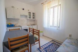 uma cozinha com uma mesa e duas cadeiras e uma mesa e uma cozinha em Apartmani Nedjeljko em Čunski