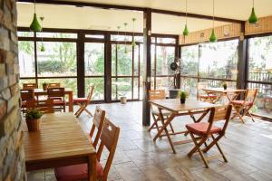 Un restaurante con mesas y sillas de madera y ventanas. en Hotel Solar, en Focşani
