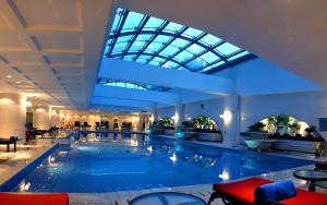 une grande piscine dans un hôtel doté d'un plafond en verre dans l'établissement Sheraton Guiyang Hotel, à Guiyang