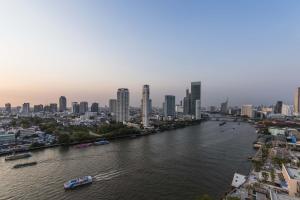 a river with a city in the background at Chatrium Hotel Riverside Bangkok in Bangkok