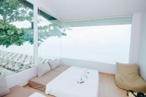 a living room with a couch and a large window at Amanda อามันดา in Ban Pak Ba Ra