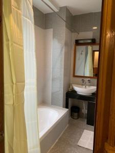 a bathroom with a bath tub and a sink at Khamsum Inn in Thimphu