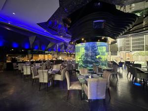 a restaurant with tables and chairs and a large aquarium at Centara Azure Hotel Pattaya in Pattaya Central