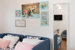 a living room with a blue couch and some pictures on the wall at Apartment Dida i Mara in Malinska