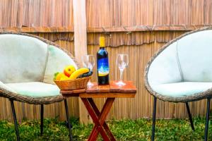 Amanya Star Bed Amboseli في أمبوسيلي: طاولة مع زجاجة من النبيذ وسلة من الفواكه