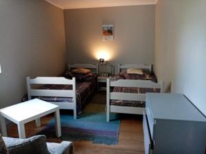 a small room with two beds and a table at Agroturystyka Camp4x4 in Nosów