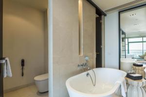 a bathroom with a bath tub and a toilet at Chatrium Hotel Riverside Bangkok in Bangkok