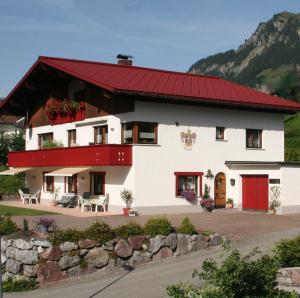 een groot wit huis met een rood dak bij Haus Anita in Wald am Arlberg