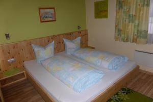 uma cama com almofadas num quarto em Haus Anita em Wald am Arlberg