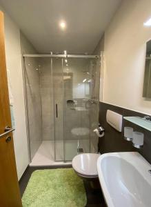 uma casa de banho com um chuveiro, um WC e um lavatório. em Haus Anita em Wald am Arlberg
