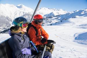 twee personen in een skilift op een besneeuwde berg bij Haus Anita in Wald am Arlberg