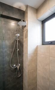 La salle de bains est pourvue d'une douche avec un pommeau de douche. dans l'établissement Kazbegi MaNa Apartment N 111, à Kazbegi
