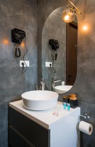 W łazience znajduje się duża, biała umywalka i lustro. w obiekcie Kazbegi MaNa Apartment N 111 w mieście Stepancminda