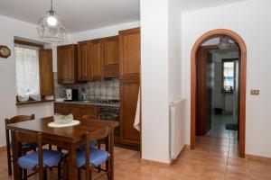 una cocina con armarios de madera, mesa y sillas en alloggio del Viandante, en Montefiascone