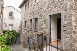 a stone building with a door and a balcony at alloggio del Viandante in Montefiascone