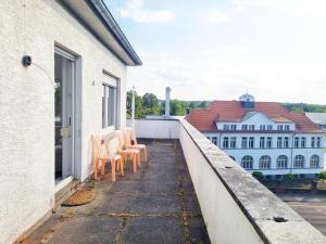 una fila de sillas sentadas en un balcón en Fully equipped Cozy Apartment en Hanau am Main