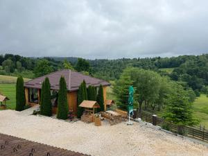 une vue de tête sur une maison avec une table et des bancs dans l'établissement Casa Bradet, à Întorsura Buzăului