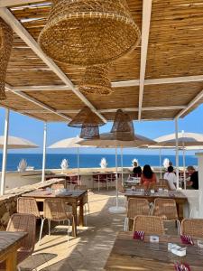 un ristorante con tavoli e sedie e vista sull'oceano di I Bastioni San Domenico - Boutique Hotel a Gallipoli