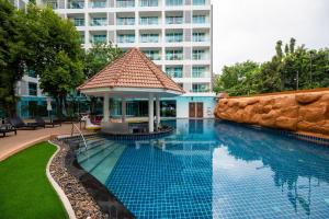 a swimming pool with a gazebo next to a building at Centara Pattaya Hotel in Pattaya