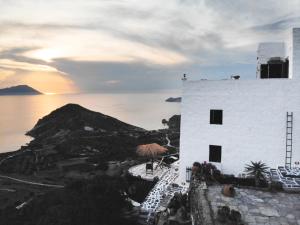 a white building with a view of the ocean at Castrum Traditional Sunset Suites in Plaka Milou +47 photos