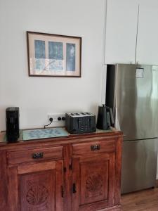 a kitchen with a wooden cabinet with a refrigerator at Willows Cottage in Warburton