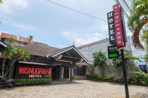 una señal de hotel frente a un edificio en Urbanview Hotel Syariah Wisnugraha by RedDoorz, en Yogyakarta