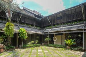 an external view of a building with a courtyard at Urbanview Hotel Syariah Wisnugraha by RedDoorz in Yogyakarta