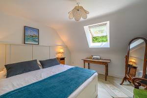 a bedroom with a bed and a mirror and a window at Ty Chaumière - Charmante Petite Chaumière en pierre avec jardin in Theix