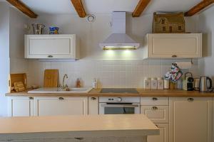 Kuchyň nebo kuchyňský kout v ubytování Ty Chaumière - Charmante Petite Chaumière en pierre avec jardin + 14 fotografií