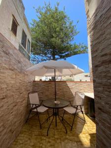 a table and chairs with an umbrella on a patio at Case Gandolfo in Favignana