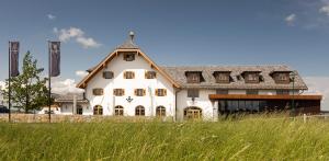 uma grande casa branca com um telhado de gambrel em Gutshof Seenland em Seekirchen am Wallersee