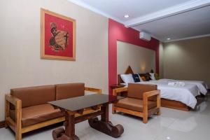 pokój hotelowy z łóżkiem, stołem i krzesłami w obiekcie Urbanview Hotel Syariah Wisnugraha by RedDoorz w mieście Yogyakarta