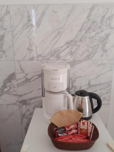 a coffee maker on a counter next to a basket of candy at Apartmani Urlic in Sreser