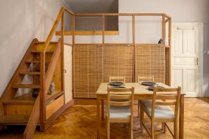 une salle à manger avec une table, des chaises et un escalier dans l'établissement Apartment with FREE Parking, à Budapest