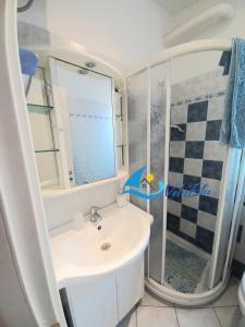 een badkamer met een wastafel en een douche bij Casa Gino in San Bartolomeo al Mare