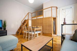 - un salon avec une table et un escalier dans l'établissement Apartment with FREE Parking, à Budapest