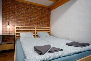 Ce lit se trouve dans une chambre dotée d'un mur en briques. dans l'établissement Apartment with FREE Parking, à Budapest