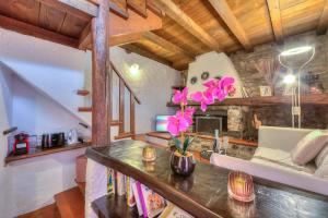 ein Wohnzimmer mit einem Tisch mit Blumen darauf in der Unterkunft Rustico Romantico Brè - Happy Rentals in Lugano