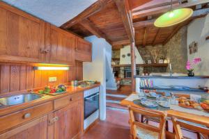 eine Küche mit Holzschränken, einer Spüle und einem Tisch in der Unterkunft Rustico Romantico Brè - Happy Rentals in Lugano