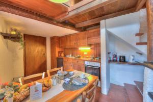eine Küche mit einem Tisch und einem weißen Kühlschrank in der Unterkunft Rustico Romantico Brè - Happy Rentals in Lugano