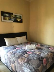 una camera da letto con un letto fiorito di Werkudara Guest House ad Ubud