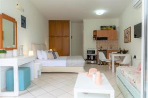 a room with a bed and a kitchen and a living room at Cretan Experiences in Agia Pelagia