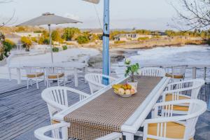 a table and chairs with a bowl of fruit on it at Villa Waru in Nusa Lembongan